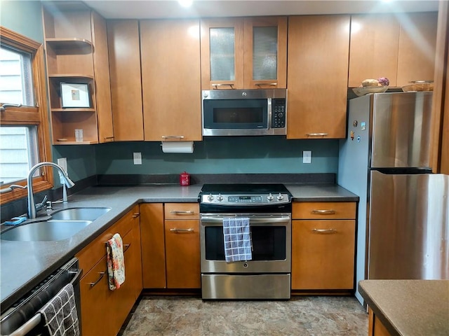 kitchen with glass insert cabinets, brown cabinets, appliances with stainless steel finishes, open shelves, and a sink