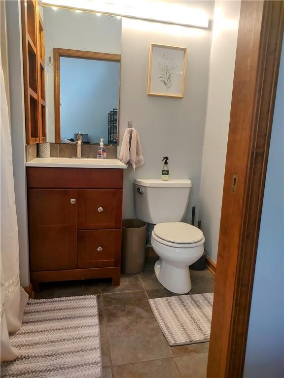 bathroom featuring tile patterned flooring, vanity, and toilet