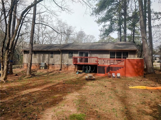 back of property featuring crawl space and a wooden deck