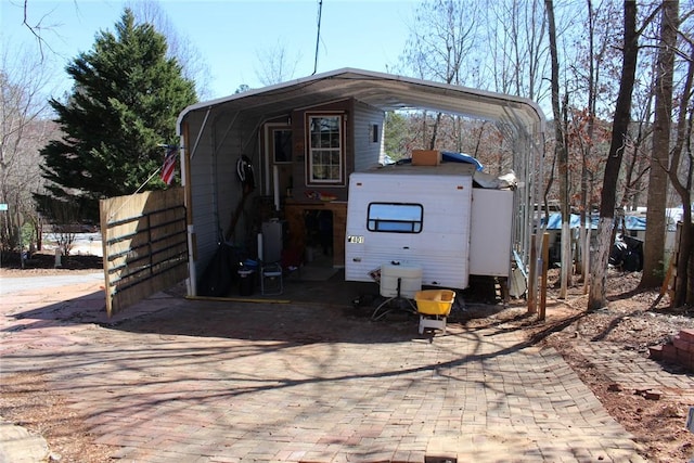 view of outbuilding featuring a carport and fence