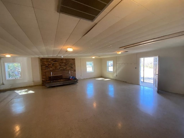 unfurnished living room featuring plenty of natural light, visible vents, and finished concrete floors