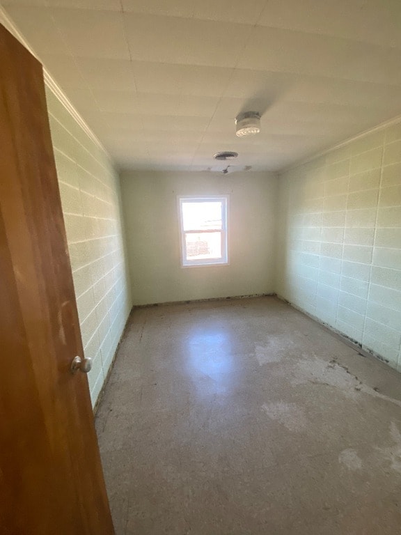 unfurnished room with concrete block wall