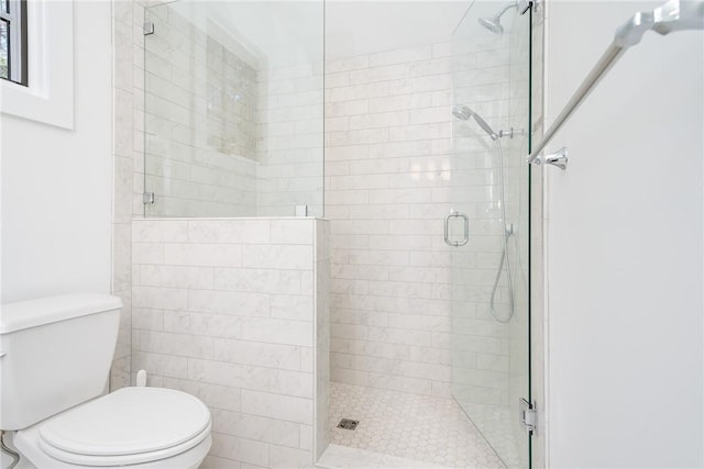 bathroom with a shower stall and toilet