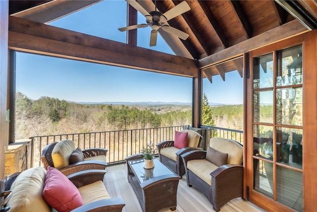 exterior space featuring a forest view, ceiling fan, and an outdoor living space