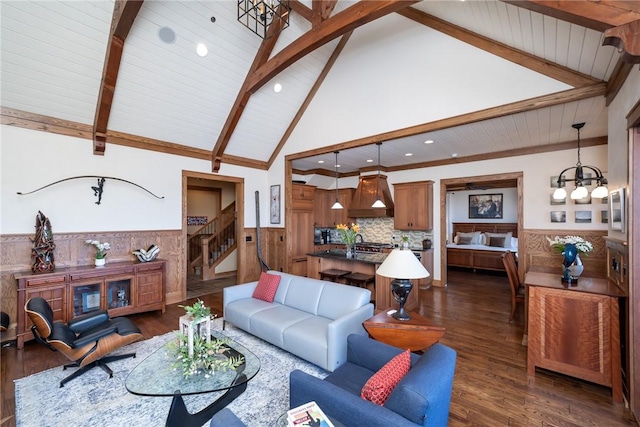 living area featuring dark wood-type flooring, stairs, wainscoting, beamed ceiling, and an inviting chandelier