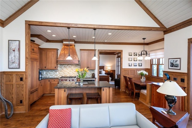 kitchen with a wainscoted wall, premium range hood, vaulted ceiling with beams, and stove