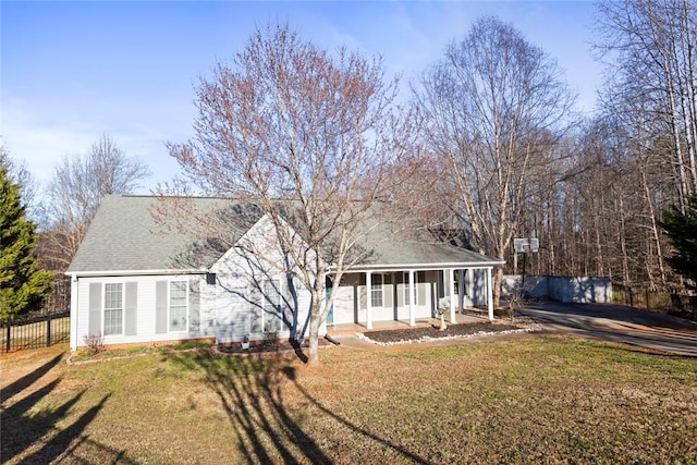 view of front of home featuring a sunroom, a shingled roof, fence, and a front lawn