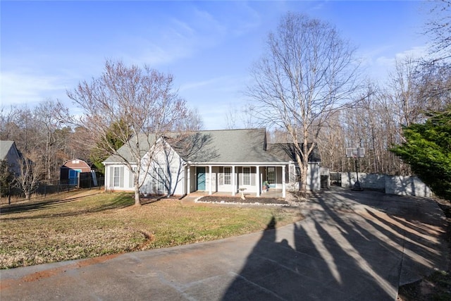 view of front of property with a sunroom, a front yard, concrete driveway, and fence