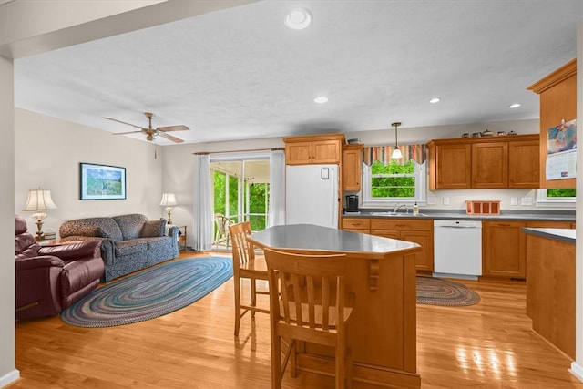 kitchen with light wood-type flooring, white appliances, plenty of natural light, and open floor plan