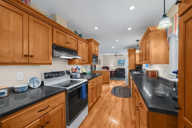 kitchen featuring built in microwave, range with electric stovetop, under cabinet range hood, and dark countertops