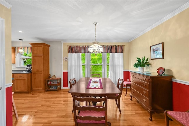 dining space with ornamental molding and light wood-type flooring