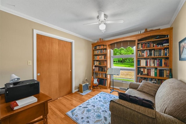 sitting room featuring ornamental molding, a ceiling fan, visible vents, and wood finished floors