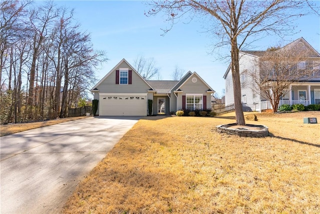 traditional-style house with an attached garage, fence, a front lawn, and concrete driveway