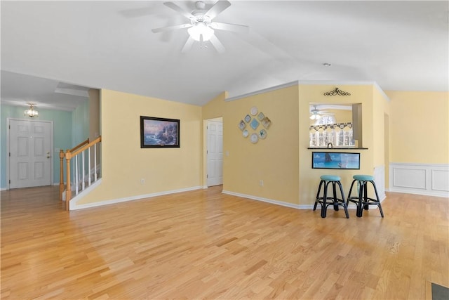 unfurnished living room featuring light wood-style flooring, vaulted ceiling, stairway, and a ceiling fan