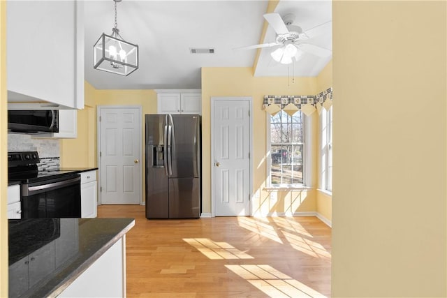 kitchen with stainless steel appliances, visible vents, white cabinets, light wood finished floors, and tasteful backsplash