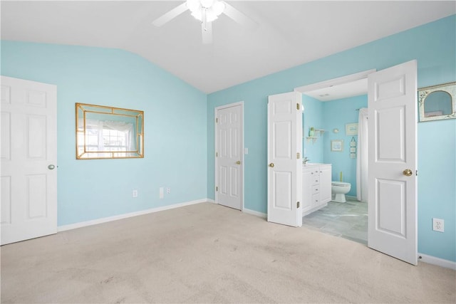 unfurnished bedroom featuring baseboards, a ceiling fan, connected bathroom, lofted ceiling, and carpet floors