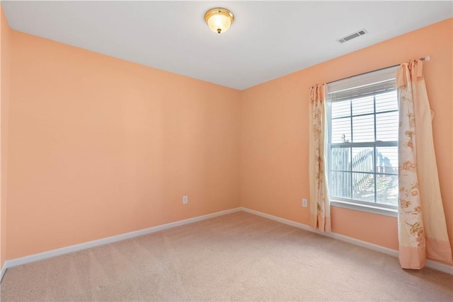 unfurnished room with baseboards, visible vents, and light colored carpet