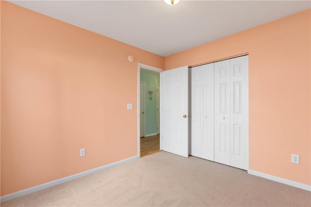 unfurnished bedroom with carpet floors, a closet, and baseboards