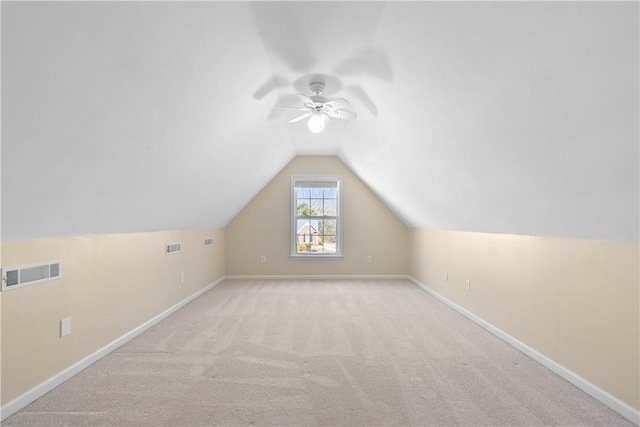 additional living space with carpet, baseboards, visible vents, and vaulted ceiling