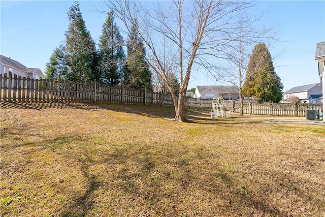 view of yard with central air condition unit and fence