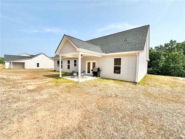 back of house featuring a patio, french doors, and a shingled roof