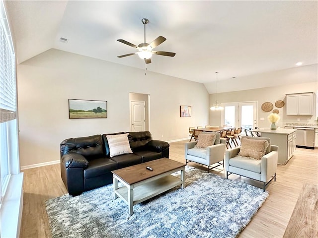 living room with vaulted ceiling, baseboards, visible vents, and light wood-style floors