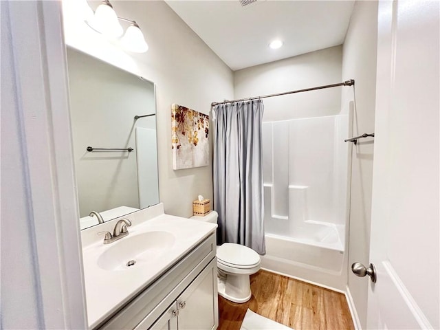 full bathroom featuring visible vents, toilet, wood finished floors, shower / bath combo with shower curtain, and vanity