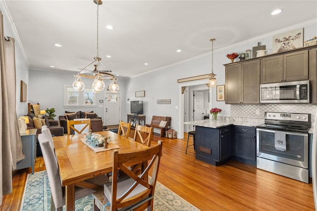 dining space with light wood-style floors, crown molding, and recessed lighting