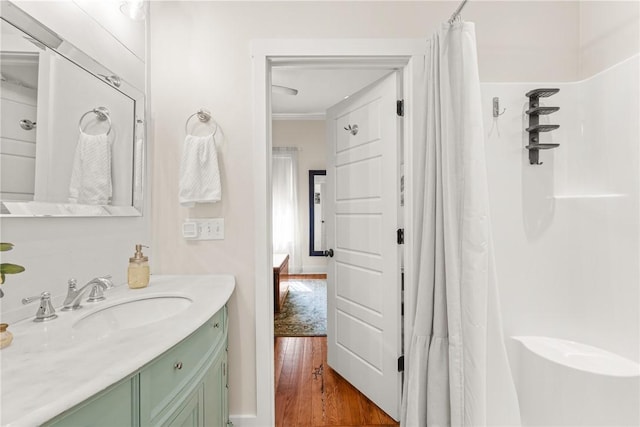 full bath with a shower with shower curtain, ornamental molding, wood finished floors, and vanity