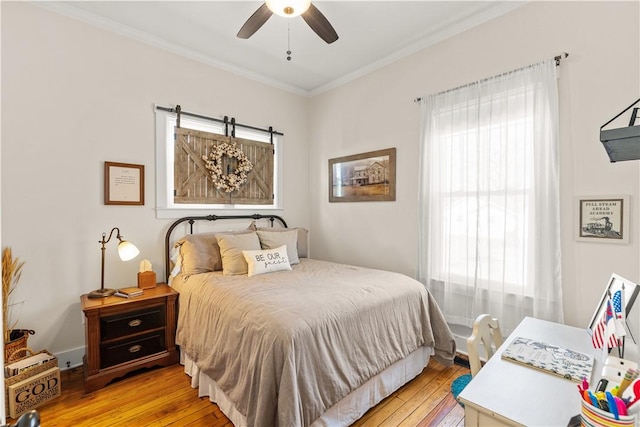 bedroom with crown molding, light wood-style flooring, and ceiling fan