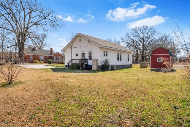 rear view of property featuring an outbuilding and a yard