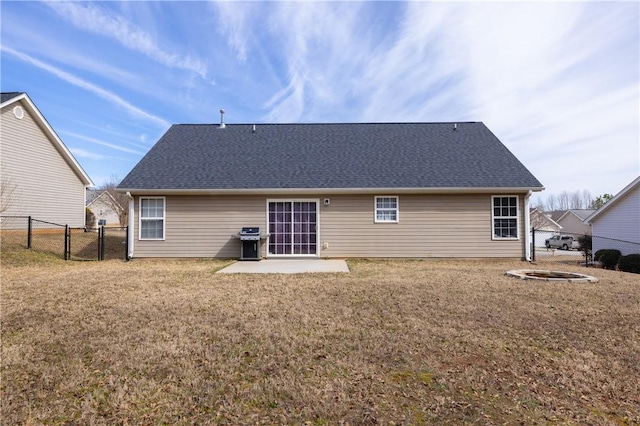 back of house featuring roof with shingles, a lawn, a gate, a patio area, and fence