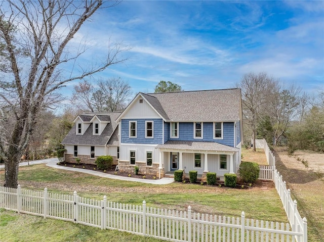 view of front facade featuring stone siding, a fenced front yard, a gate, a porch, and a front yard