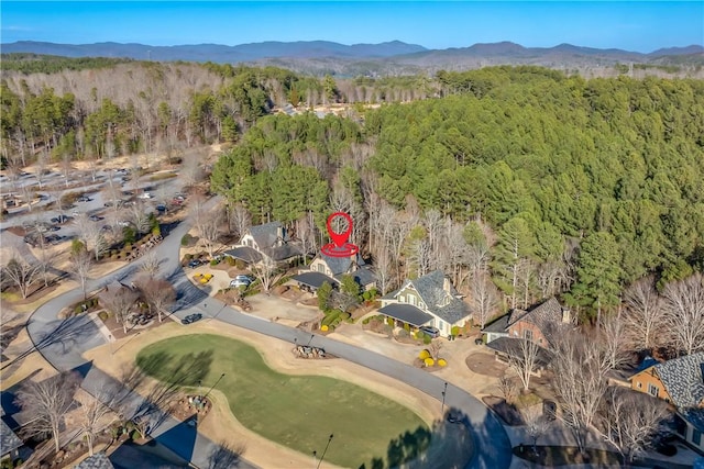 drone / aerial view with a wooded view and a mountain view