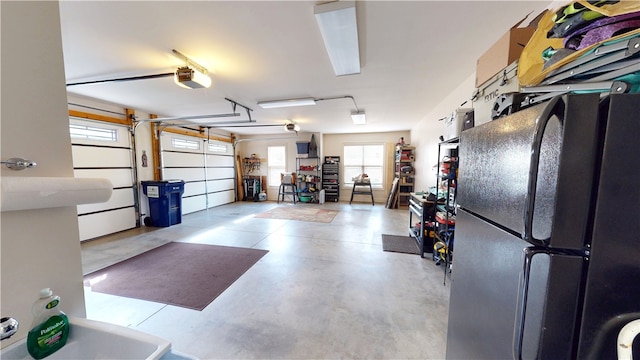 garage with a garage door opener and freestanding refrigerator