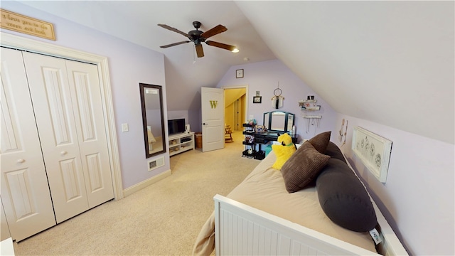 bedroom with ceiling fan, light colored carpet, visible vents, vaulted ceiling, and a closet