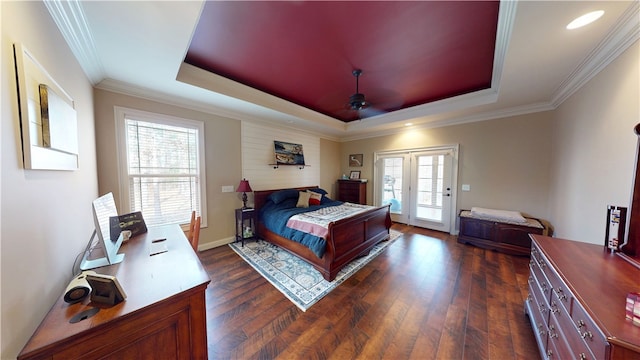 bedroom with access to outside, a tray ceiling, dark wood-type flooring, and crown molding