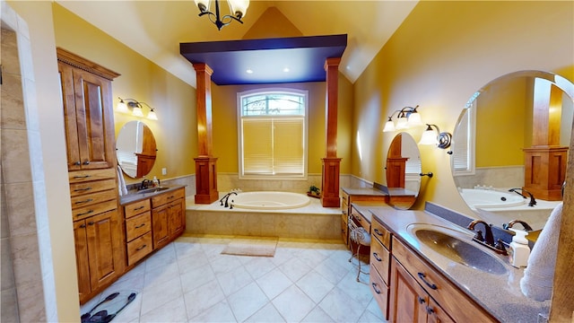 bathroom featuring decorative columns, two vanities, a sink, a bath, and tile patterned floors