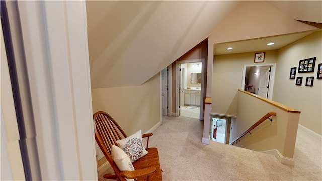 corridor featuring recessed lighting, carpet flooring, vaulted ceiling, an upstairs landing, and baseboards