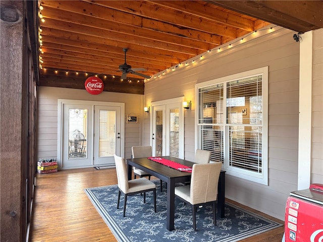 exterior space with lofted ceiling with beams, wood walls, ceiling fan, and wood finished floors