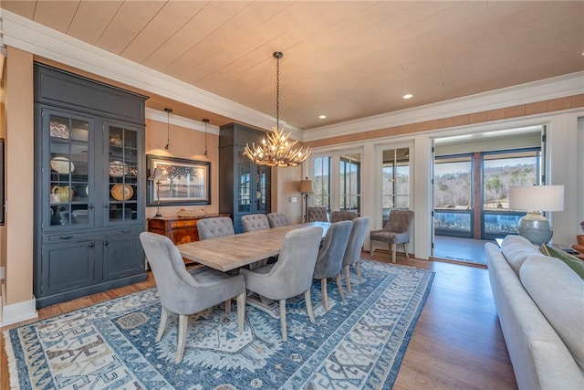 dining room with ornamental molding, an inviting chandelier, light wood-style flooring, and a healthy amount of sunlight