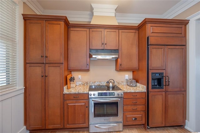 kitchen featuring stainless steel electric range oven, paneled refrigerator, brown cabinets, and under cabinet range hood