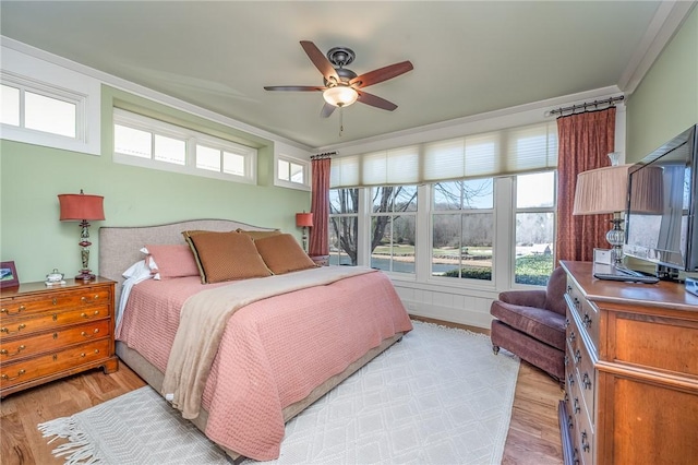 bedroom featuring ceiling fan, ornamental molding, and light wood-style floors