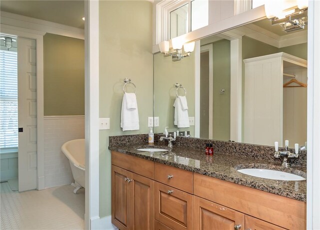 full bath with double vanity, a soaking tub, a sink, and a notable chandelier