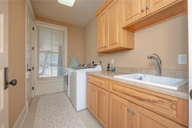 laundry room featuring cabinet space, light tile patterned floors, washer and dryer, and a sink