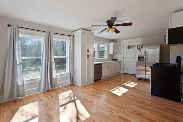 kitchen featuring white cabinets, light wood-style floors, plenty of natural light, and stainless steel appliances