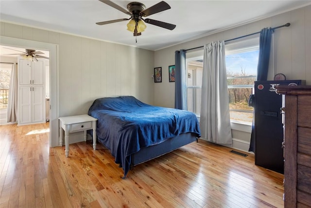 bedroom featuring visible vents, multiple windows, and light wood-style flooring