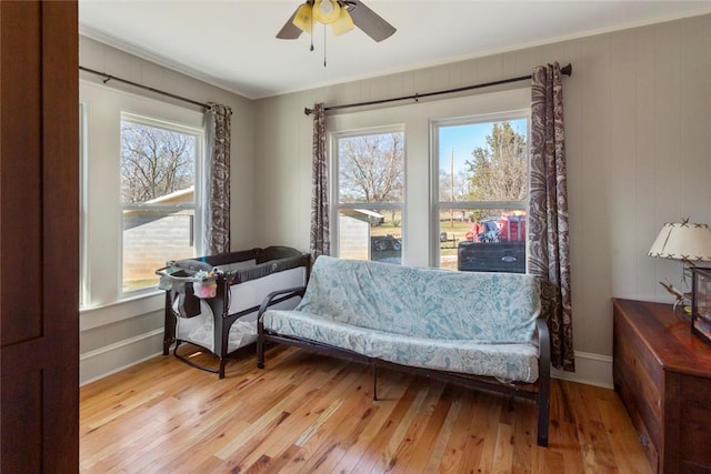 sitting room featuring baseboards, ceiling fan, and light wood finished floors