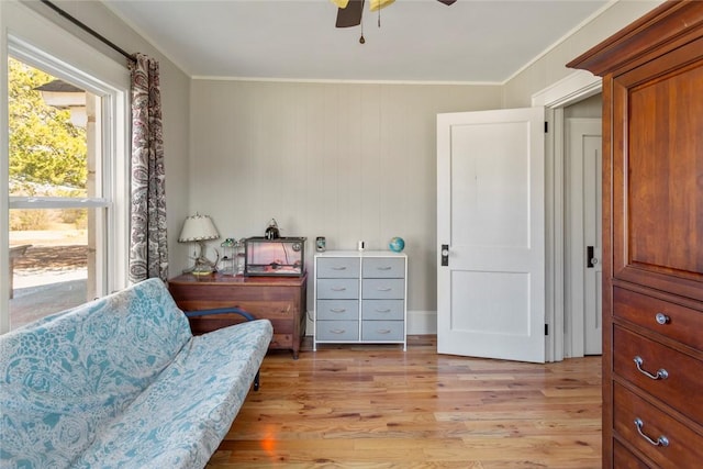 sitting room featuring ceiling fan, light wood finished floors, and ornamental molding