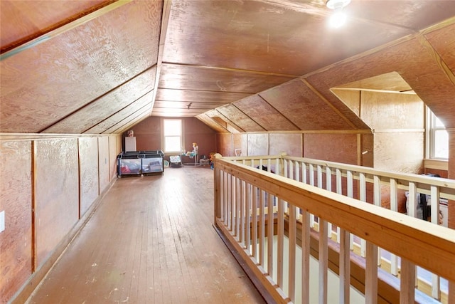 additional living space featuring vaulted ceiling and hardwood / wood-style flooring